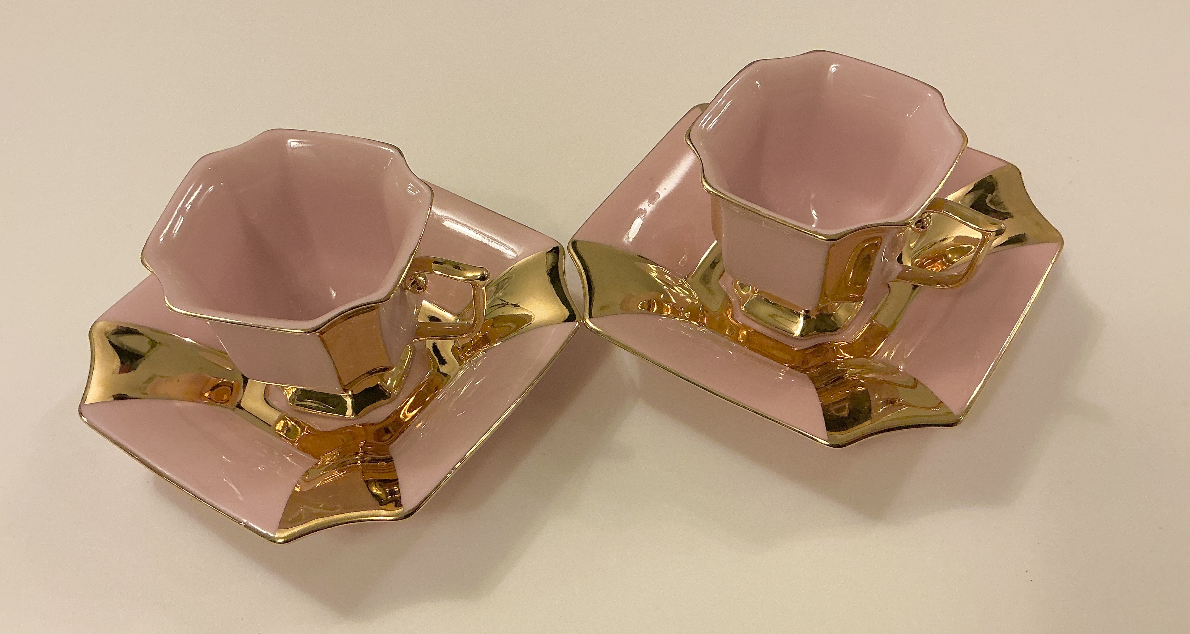 Dva k&aacute;vov&eacute; hrnky z růžov&eacute;ho porcel&aacute;nu zdobeny zlatem